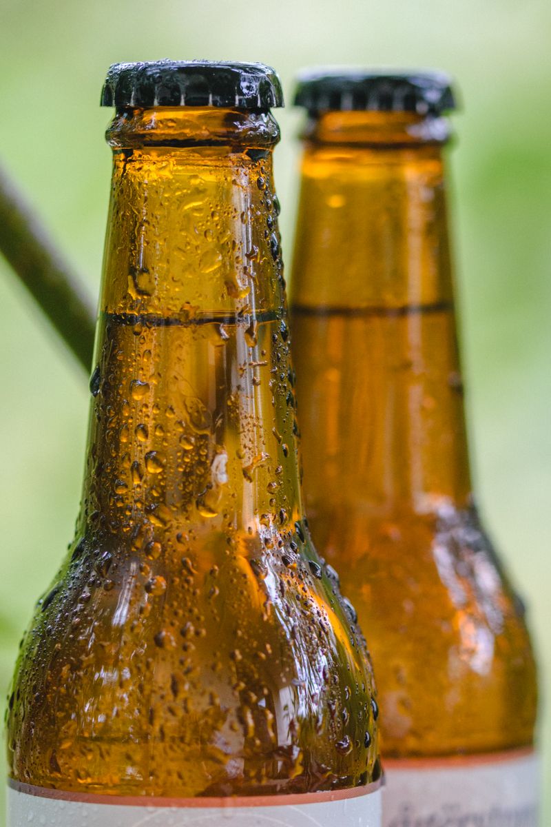 Close-up of a chilled glass bottle beaded with condensation