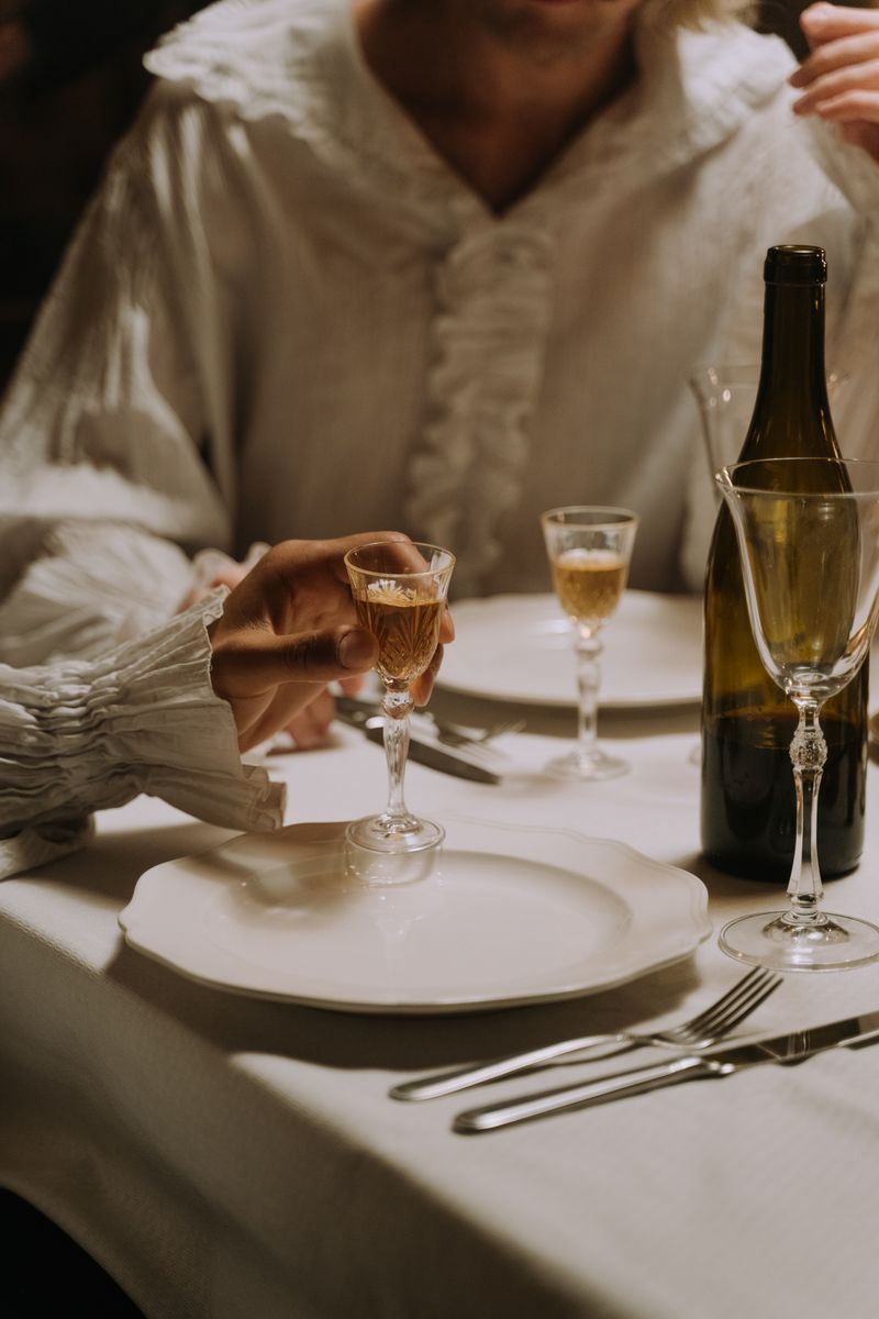An elegant hand holding a small glass bottle